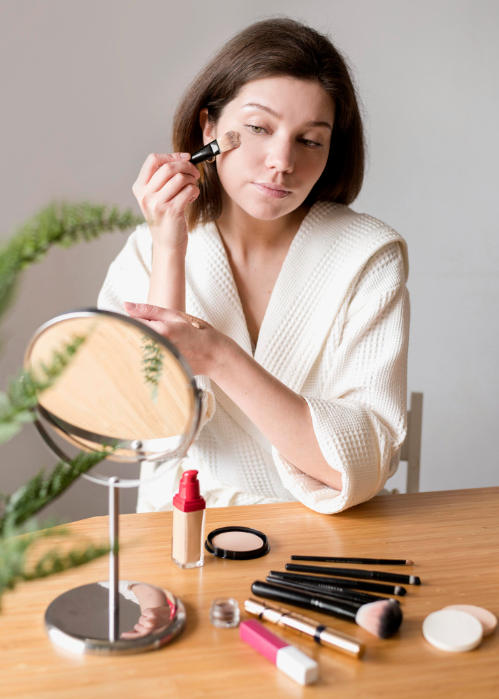 Mujer aplicando rímel frente al espejo durante su rutina de maquillaje