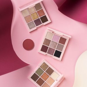 Paletas de sombras para ojos en tonos neutros sobre fondo rosa
