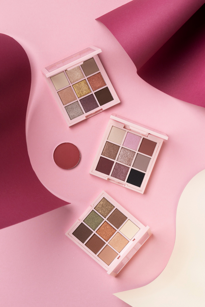 Paletas de sombras para ojos en tonos neutros sobre fondo rosa