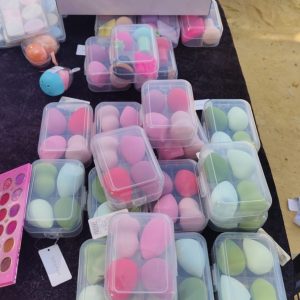 Variedad de productos de maquillaje, sombras y esponjas